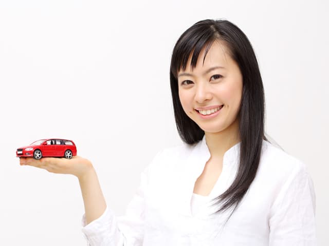 手の上に車を乗せている女性
