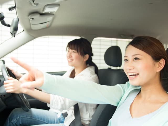 車を笑顔で運転している男女